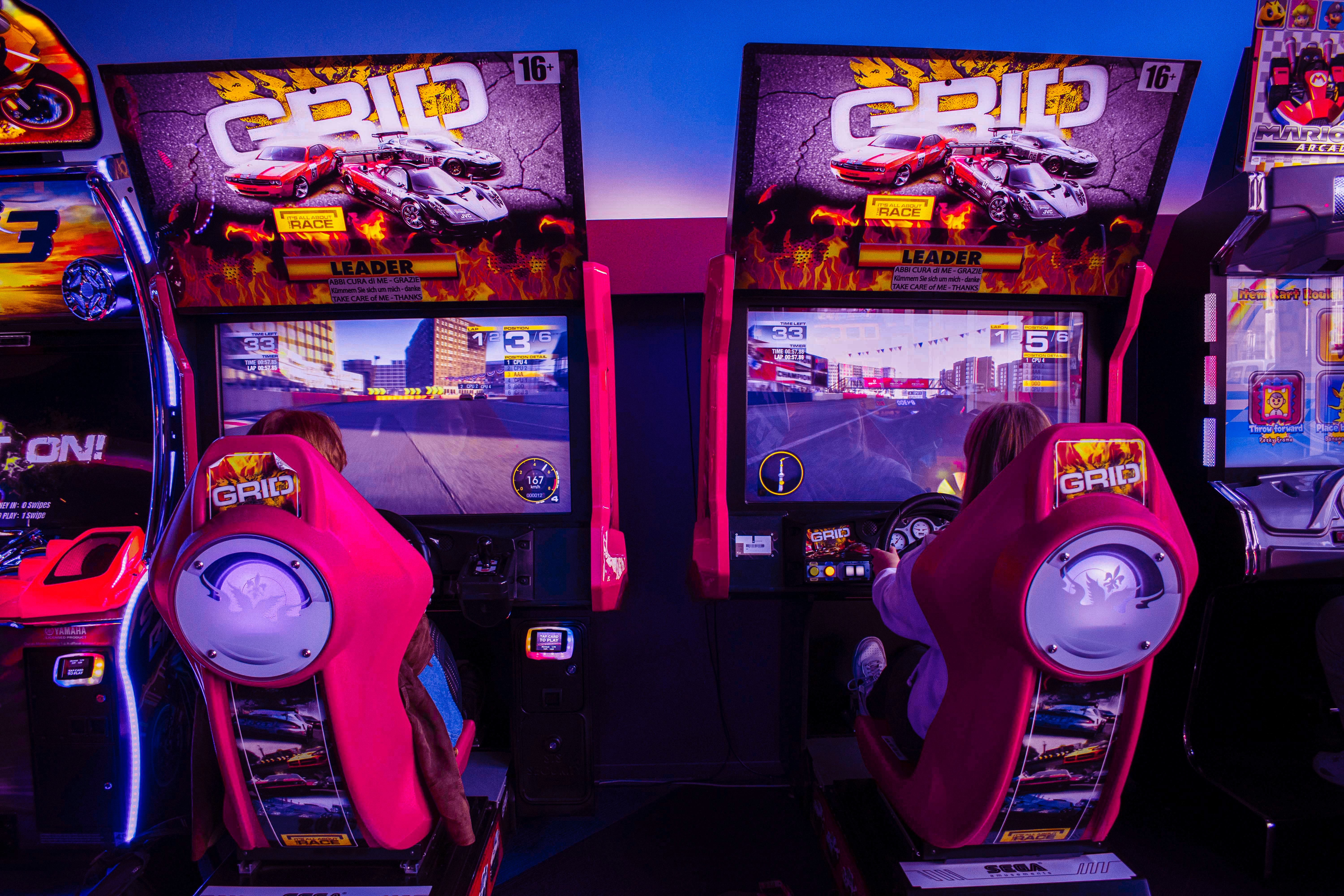 two people playing in an arcade